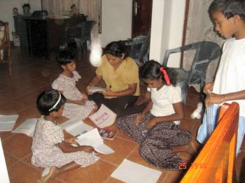 Vinitha korrigiert die Hausaufgaben der Kinder im Chathura-Kinderheim in Sri Lanka 