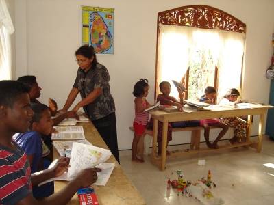 Heimmutter Vinitha hilft im neuen Schulungsraum bei den Hausaufgaben 