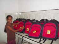 Imasha zeigt uns die neuen Schultaschen im Chathura-Kinderheim in Sri Lanka 