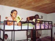 Maheshika und Indunika lesen im Bett im Chathura-Kinderheim in Sri Lanka 