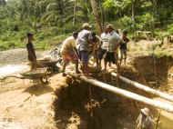 auf schwankenden Bambusstangen stehen die Arbeiter und ziehen den Schlamm und Erde hoch - Bauarbeiten beim Chathura-Kinderheim in Sri Lanka 