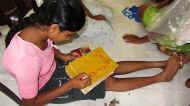 Disna im Chathura-Kinderheim beschriftet ihre Schulbücher in Schönschrift 