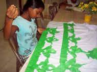 Dilhani im Chathura-Kinderheim schmueckt ihren Wesak-Sari mit gruenen Motiven 