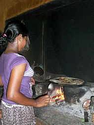 Sandamini baeckt Roti (Reismehlfladen) im Chathura-Kinderheim auf dem offenen Feuer